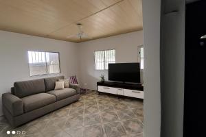 a living room with a couch and a flat screen tv at Casa Mar in Serra