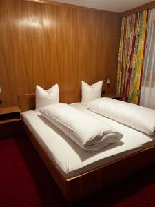 圣安东阿尔贝格Apart Dorr的一间卧室，配有两张铺有白色床单的床