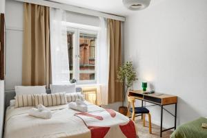 a bedroom with a bed and a desk and a window at Scandi Luxury Renovated Central Access in Helsinki