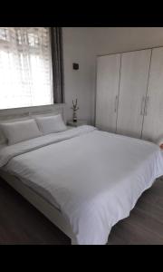 a large white bed in a bedroom with a window at Staycation Wandre in Centre de Flacq +5 photos