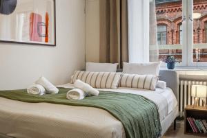 a bedroom with a bed with white pillows and a window at Scandi Luxury Renovated Central Access in Helsinki +17 photos