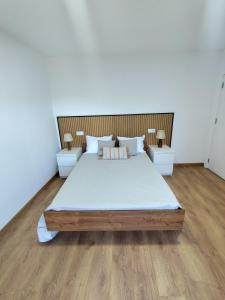 a bedroom with a large bed with two night stands at Casa do Retornado 