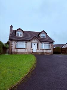 ein großes Backsteinhaus mit Auffahrt in der Unterkunft Moyle Manor in Ballycastle