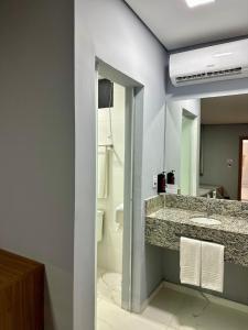 a bathroom with a sink and a mirror at Hotel Premier in Belo Horizonte