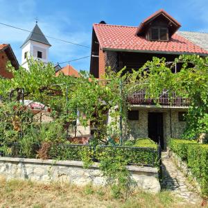 an old house with a vineyard and a church at Kuća za odmor HORVAT 