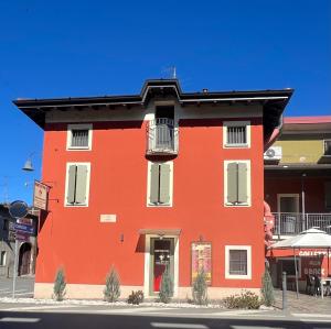 ein rotes Gebäude mit Balkon an einer Straße in der Unterkunft Meublè Telò in San Paolo