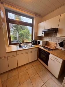 a small kitchen with a sink and a window at In't Noord Kajüte in Stick +17 photos