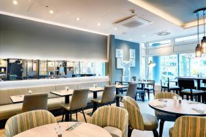 a restaurant with tables and chairs and a bar at Premier Inn Berlin City Süd in Berlin