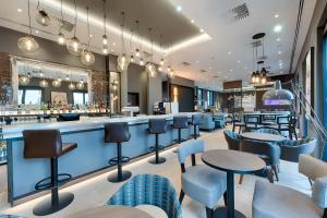 a bar in a restaurant with tables and chairs at Premier Inn Regensburg City Centre in Regensburg