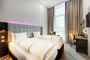 two beds in a hotel room with a desk at Premier Inn Wolfsburg City Centre in Wolfsburg +15 photos