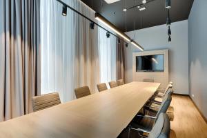 a conference room with a long wooden table and chairs at Premier Inn Wolfsburg City Centre in Wolfsburg