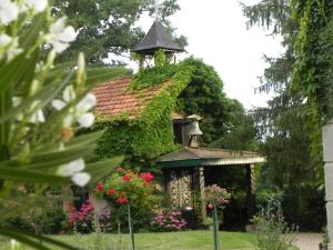 un jardín con un cenador con una campana en Les Belins, en Bourg-le-Comte