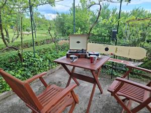 a table with a laptop computer on it next to two chairs at Kuća za odmor HORVAT 