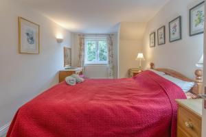 ein Schlafzimmer mit einem roten Bett mit einem Stofftier darauf in der Unterkunft Waders - 2 bedroom coastal retreat, Crabpot Cottages, Hunstanton in Hunstanton