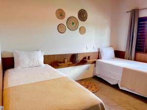 a bedroom with two beds and a window at Pousada Lençóis Eco Villa in Santo Amaro +41 photos