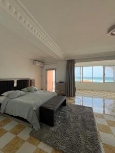 a bedroom with a large bed and a large window at Oasis luxueuse en bord de Mer Virage Dakar in Dakar