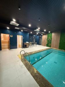 a large swimming pool in a building with at Khorazm Hotel in New Uzbekistan Park in Teshabayguzar