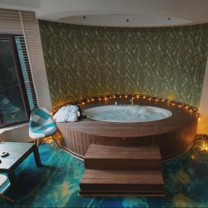een jacuzzi in een hotelkamer met een blauwe stoel bij Mavisu Deluxe Otel Restaurant in Zafanos