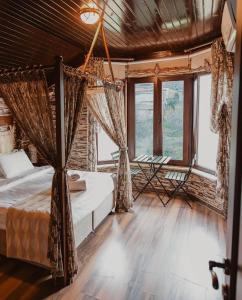 een slaapkamer met 2 bedden en grote ramen bij Mavisu Deluxe Otel Restaurant in Zafanos