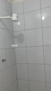 a white tiled shower with a white wall at Casa Harmonia Cariri Espaçosa e completa com 2 quartos e 2 camas de casal in Juazeiro do Norte +31 photos