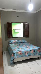 a bedroom with a bed with a tv on the wall at Casa Harmonia Cariri Espaçosa e completa com 2 quartos e 2 camas de casal in Juazeiro do Norte