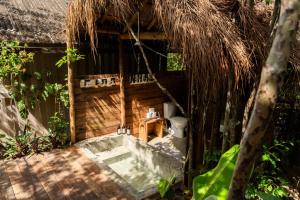 an outdoor bathroom with a toilet and a thatch roof at Na Floresta Glamping in Pôrto de Pedras