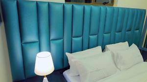 a blue headboard of a bed with white pillows at Jabulani Lodge in Johannesburg