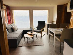 a living room with a couch and a table at Chalet Wiesehockli - CharmingStay in Flumserberg