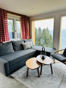 a living room with a blue couch and a table at Chalet Wiesehockli - CharmingStay in Flumserberg