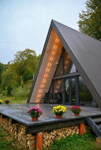 a house with a pitched roof and flowers on the porch at Дім у Карпатах in Rechka