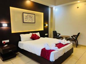 a hotel room with a bed and a table and chairs at Luxebay in Bangalore
