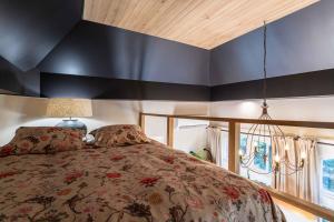 Un dormitorio con una cama y una pared negra. en Le Parc de Louette - Le Pavillon - Esc'Appart, en Gedinne