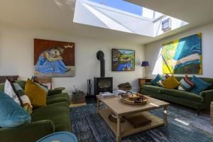 a living room with green couches and a skylight at Riverview in Brockenhurst