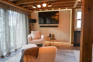 Una sala de estar con una silla y un televisor. en The Treehouse Hideaway, 