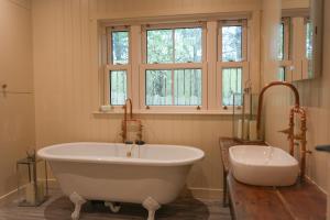 Un baño grande con bañera y ventana. en The Treehouse Hideaway, 