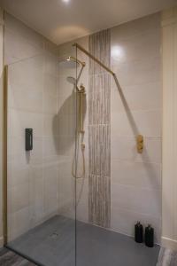 una ducha con puerta de cristal en un baño en The Treehouse Hideaway, 