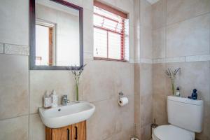 a bathroom with a sink and a toilet and a mirror at #5A on Brassie in Lakeside