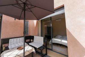 a patio with a table and an umbrella and a bed at Villa Dar El Gharrabia in Amezrou +31 photos