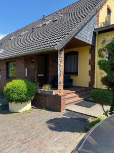 a brick house with a porch with a sign on it at In't Noord Koje in Stick