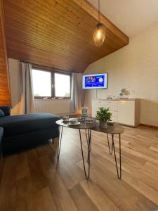 a living room with a table and a couch at In't Noord Koje in Tossens