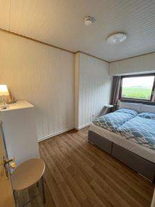 a bedroom with a bed and a window at In't Noord Kombüse in Tossens +8 photos