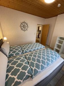 a bedroom with a large bed with blue and white comforter at In't Noord Kombüse in Stick