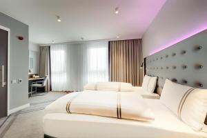 a hotel room with two beds and a desk at Premier Inn Hamburg City Klostertor in Hamburg +14 photos