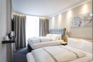 a hotel room with two beds and a tv at Premier Inn Freiburg City Süd in Freiburg im Breisgau +11 photos