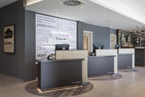 a lobby with a large wall with a large at Premier Inn Freiburg City Süd in Freiburg im Breisgau
