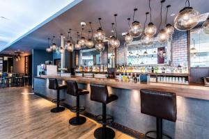 a bar with black stools in a restaurant at Premier Inn Hamburg City Alster in Hamburg