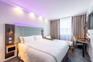 a hotel room with a large bed and a desk at Premier Inn Hamburg City Alster in Hamburg +11 photos
