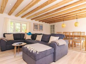 ein Wohnzimmer mit einem blauen Sofa und einem Tisch in der Unterkunft 4 star holiday home in Gedser in Gedser