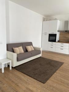 a living room with a couch and a kitchen at Casa Moniga-Residenze Lizzeri in Moniga