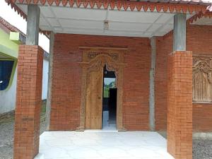 an entrance to a brick building with a wooden door at Joglo Hexa in Bugisan +1 photo